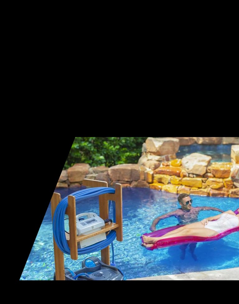 Dolphin robotic pool cleaner stored on a caddy beside a pool